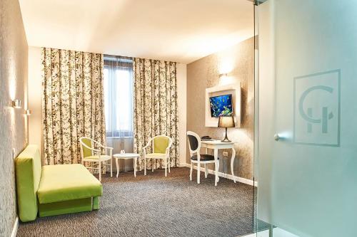 a hotel room with a table and chairs and a room at Continental Forum Sibiu in Sibiu
