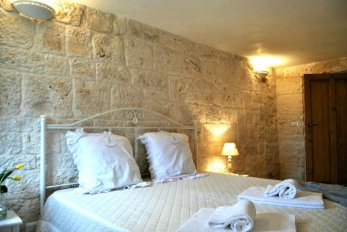アルベロベッロにあるTrulli Sciummo Relaisの石壁のベッドルーム1室
