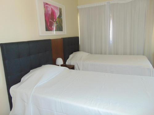 two beds in a hotel room with white sheets at Princesa do Gilão in Tavira