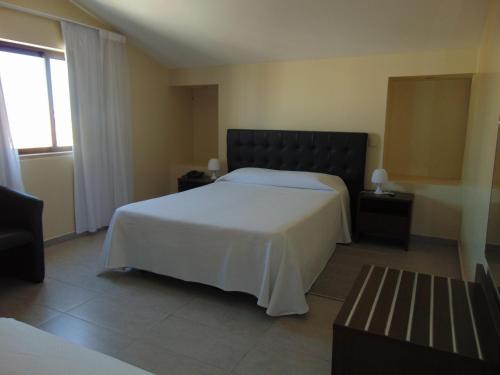 a bedroom with a large white bed and a window at Princesa do Gilão in Tavira