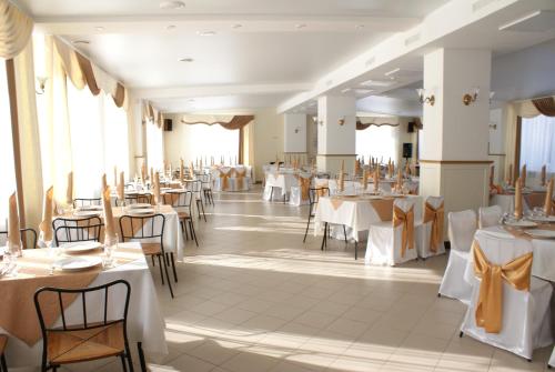 a dining room with tables and chairs with white tablecloths at Yasnaya Polyana in Arzamas