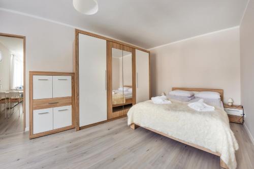 a bedroom with a bed and a large mirror at Szkolna, Sun & Snow in Międzywodzie