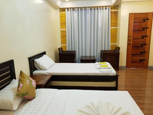 pokój hotelowy z 2 łóżkami i oknem w obiekcie EDUARDO'S RESORT w mieście Calapan