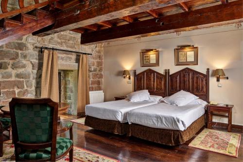 a bedroom with a large bed and a chair at Parador de Olite in Olite
