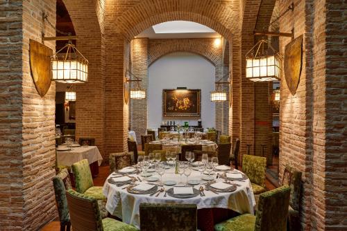 een eetkamer met tafels en stoelen met verlichting bij Parador de Olite in Olite