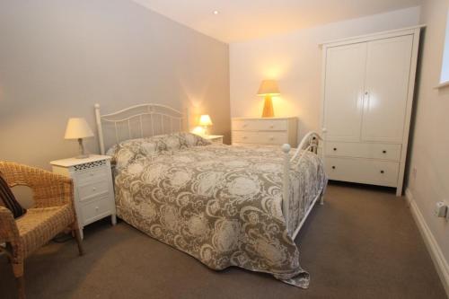 a bedroom with a bed and two night stands and a chair at Binswood Garden Apartment in Leamington Spa