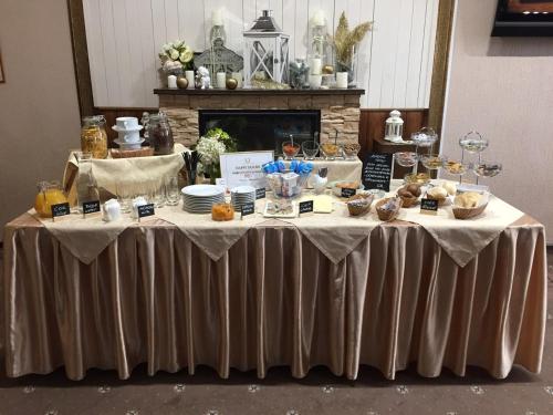 a table with food on it in front of a fireplace at Green Roof Hotel in Izhevsk