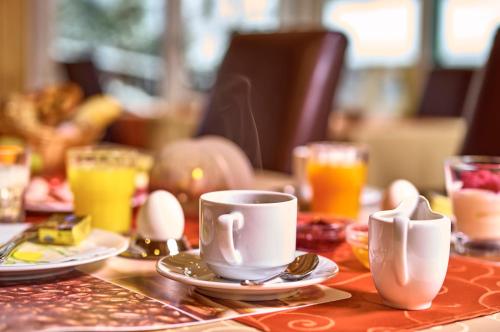a table with two coffee cups and eggs on it at Rehwinkel in Bodenmais