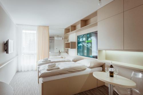奧洛穆茨的住宿－Smarthotel Nezvalova Archa，一间卧室配有两张床和一张桌子