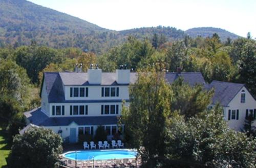 a large house with a swimming pool in front of it at Inn at Ellis River in Jackson
