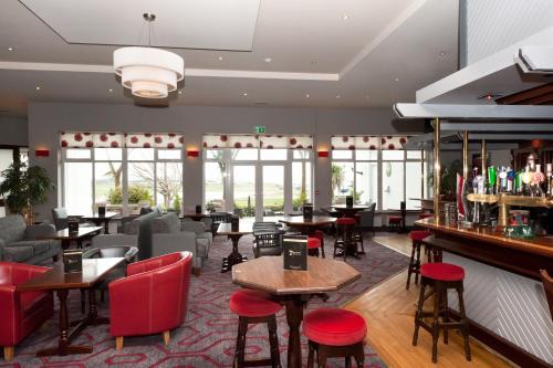 um restaurante com mesas e cadeiras e um bar em Majestic Hotel em Tramore