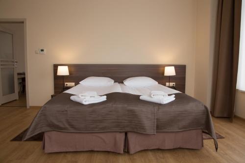 1 dormitorio con 1 cama grande y 2 toallas. en Glas-Hotel 4* en Żary