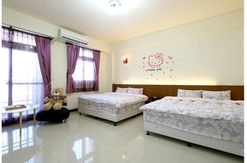 a bedroom with two beds and a teddy bear in it at Hometown Times Homestay in Yuli