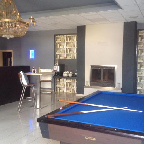 a room with a pool table and a kitchen at Hotel Restaurant Fritz in Gronau