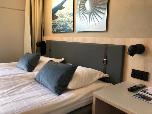 a bedroom with a bed with two pillows on it at Pilot Airport Hotel in Vantaa