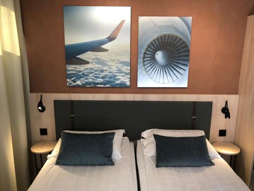 a bedroom with two beds with a picture of an airplane at Pilot Airport Hotel in Vantaa