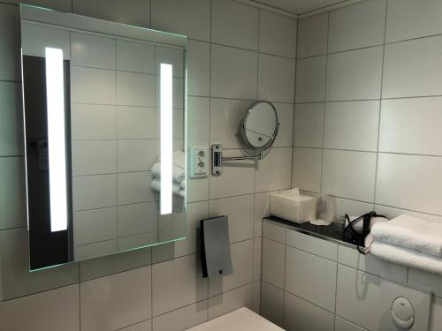 a bathroom with a mirror and a toilet and towels at Pilot Airport Hotel in Vantaa