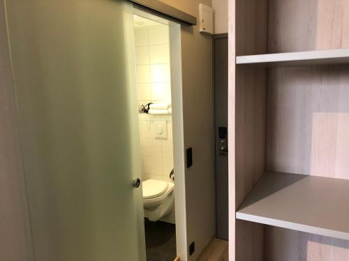 a small bathroom with a toilet and a closet at Pilot Airport Hotel in Vantaa