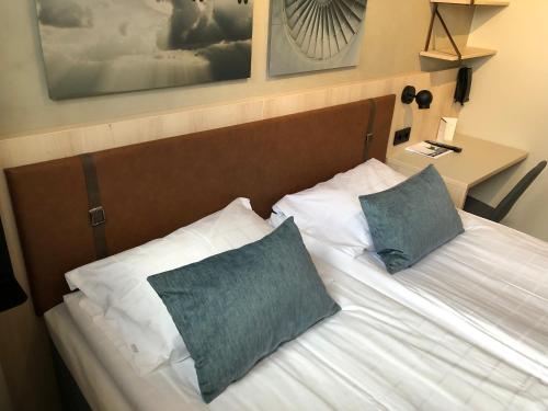 a bedroom with a bed with two pillows on it at Pilot Airport Hotel in Vantaa