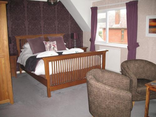 a bedroom with a bed and a chair at The Kenbury B&B in Shanklin