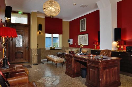 Elle comprend un salon avec des murs rouges et un bureau. dans l'établissement Hotel Domstern, à Cologne