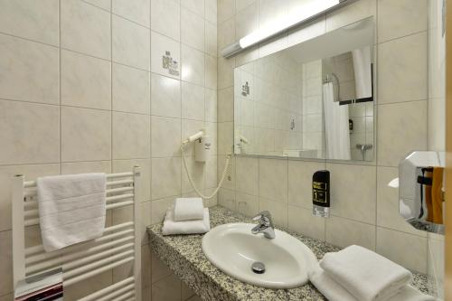 a bathroom with a sink and a mirror at Hotel Domstern in Cologne