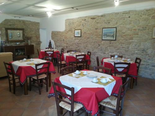 a dining room with tables with red and white tablecloths at Il Borghetto in Todi