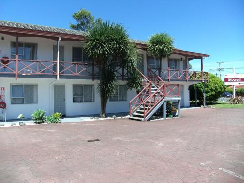 a building with a staircase in front of it at Burgundy Rose Motel in Whangarei