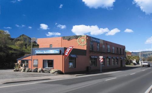 a building on the side of a road next to a street at Harbourview Stadium Hotel in Dunedin