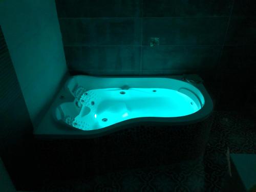 a blue bath tub in a dark room at Kinneret Lodging in Tiberias