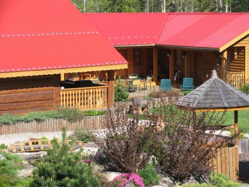 a house with a red roof and a garden at Blue Grouse Country Inn B&B in Clearwater
