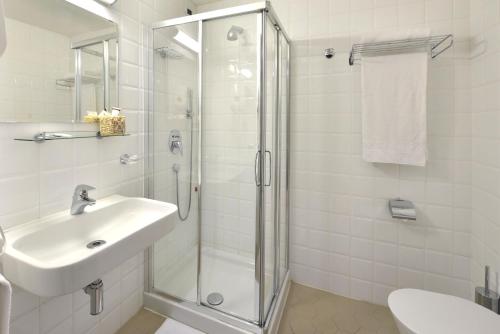 a white bathroom with a shower and a sink at Casa I Cappuccini in Rome