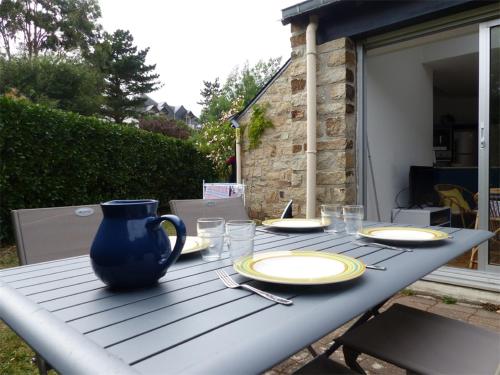 een picknicktafel met borden en een blauwe vaas erop bij Maisons Port en Dro 1 in Carnac