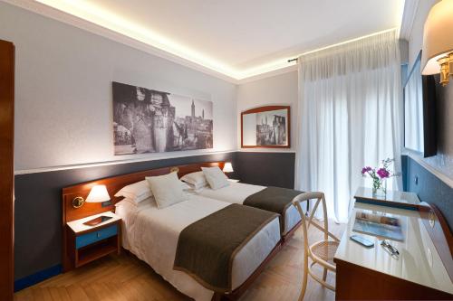 una camera d'albergo con un grande letto e una scrivania di Mastino Rooms a Verona