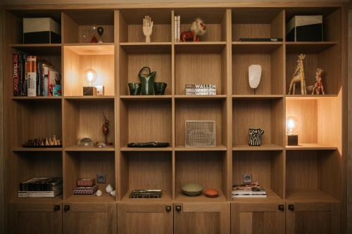 a large wooden book shelf with various items on it at The Times Hotel in Amsterdam
