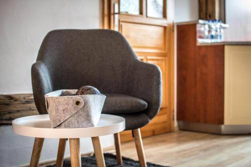 a chair and a table with a bowl on a stool at Tylova Apartments in Kutná Hora