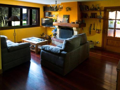 a living room with two couches and a fireplace at Casa Rural Olazi in Oiartzun