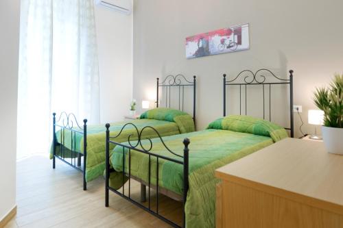 two beds in a room with a blue wall at B&B La dimora di Katiu' in Palermo