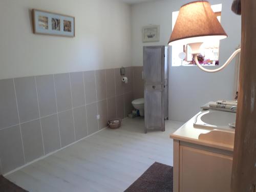 a bathroom with a sink and a toilet in a room at Au Cœur de Mauchat in Saint-Martin-de-Fressengeas