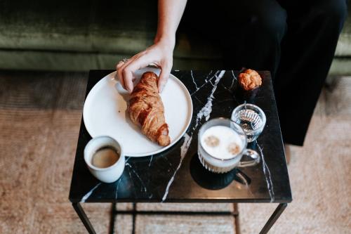 a person holding a plate of food on a table at The Times Hotel in Amsterdam