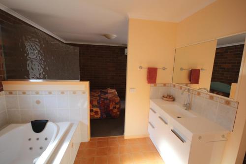 bagno con 2 lavandini e vasca di Rubyvale Motel & Holiday Units - An Adults Only Getaway a Rubyvale