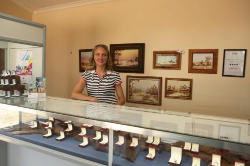 a woman standing in front of a display case of shoes at Rubyvale Motel & Holiday Units - An Adults Only Getaway in Rubyvale