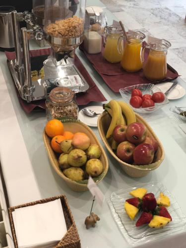 a table with three bowls of fruit on it at Aparthotel Bahia Pinosol in Jávea