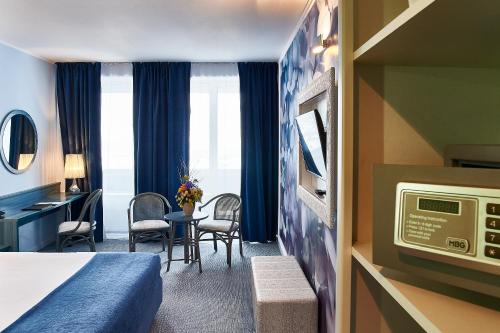 アラドにあるコンチネンタル フォーラム アラドのベッドとデスクが備わるホテルルームです。