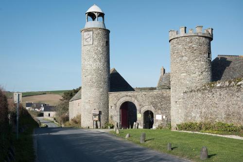 a building with two towers on the side of a road at Les Chambres du Château du Rozel in Le Rozel