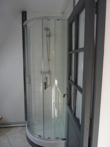 a shower with a glass door in a bathroom at B&B La Baronniére in Cordebugle