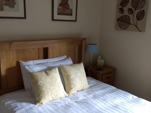 a bed with white sheets and two pillows on it at The Old Rectory Bed and Breakfast in Ruthin