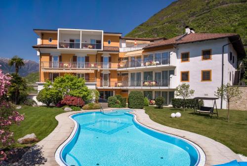 a resort with a swimming pool in front of a building at Hotel Garni Günther in Postal