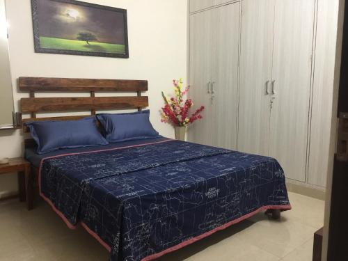 a bedroom with a bed with a blue comforter at The Raveesh E24 - 2BHK Serviced Apartment in New Delhi