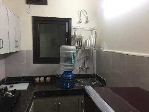 a bottle of water is sitting on a kitchen counter at The Raveesh E24 - 2BHK Serviced Apartment in New Delhi